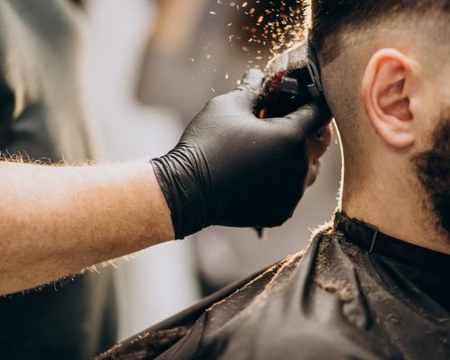 cliente-facendo-taglio-di-capelli-in-un-salone-di-barbiere_1303-20787