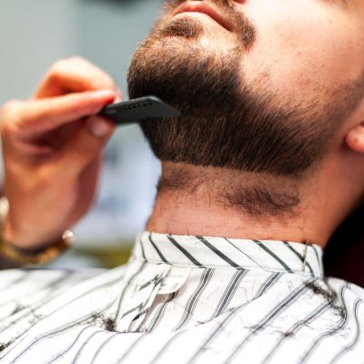 parrucchiere-che-pettina-la-barba-del-cliente_23-2148256922